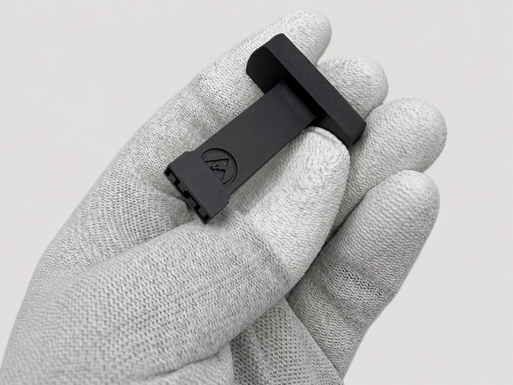 Schwarze Vakuum-Nozzle für eine industrielle Kennzeichnungsanlage auf einem weißen Handschuh.